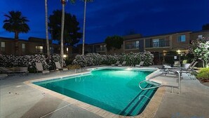 A swimming pool with lounge chairs and palm trees. - Parktopia By Signature Vacation Rentals (Scottsdale)