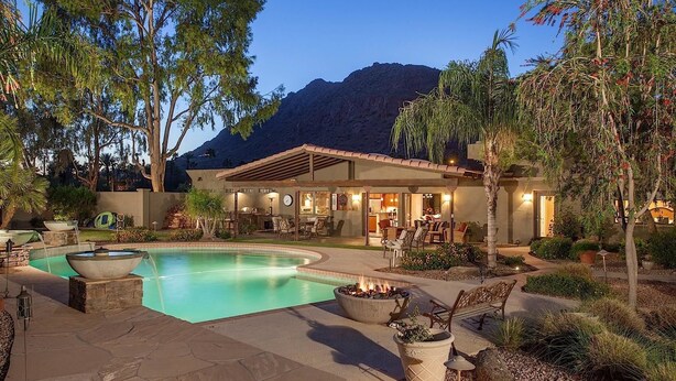A pool area with a fire pit, outdoor seating, and a mountain backdrop. - Paradise Retreat - PV622 By Signature Vacation Rentals (Scottsdale)