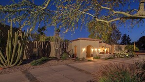A residential property with a patio, cacti, and a building with arched entryways. - Paradise Retreat - PV622 By Signature Vacation Rentals (Scottsdale)