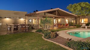 A house with a pool, outdoor seating, and a covered patio area. - Paradise Retreat - PV622 By Signature Vacation Rentals (Scottsdale)
