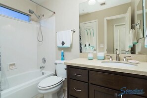 A modern bathroom with a bathtub, toilet, and sink. - Painted Horizon By Signature Vacation Rentals (Scottsdale)