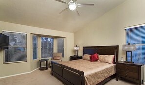 A bedroom with a bed, nightstands, a ceiling fan, and windows with blinds. - Painted Horizon By Signature Vacation Rentals (Scottsdale)