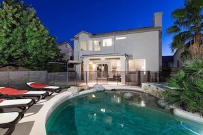 A modern house with a swimming pool, outdoor furniture, and a well-maintained garden. - Painted Horizon By Signature Vacation Rentals (Scottsdale)