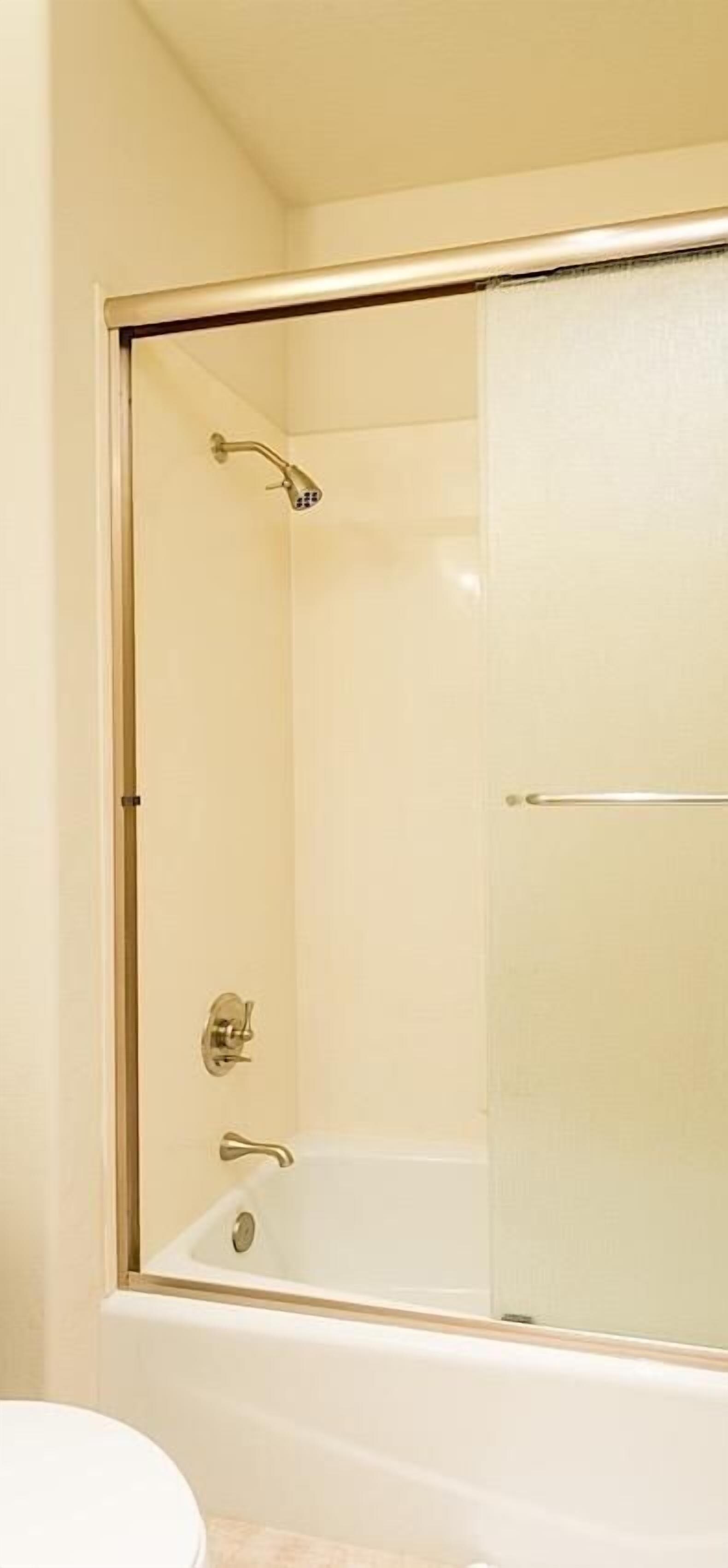 Een badkamer met een douchecabine, een bad en een toilet.
