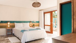 A hotel room with a bed, bedside tables, a lamp, a view through a glass door, and a wooden bench.