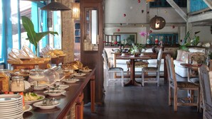 A breakfast buffet with various food items and a seating area with tables and chairs.