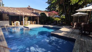 Una piscina al aire libre, tumbonas