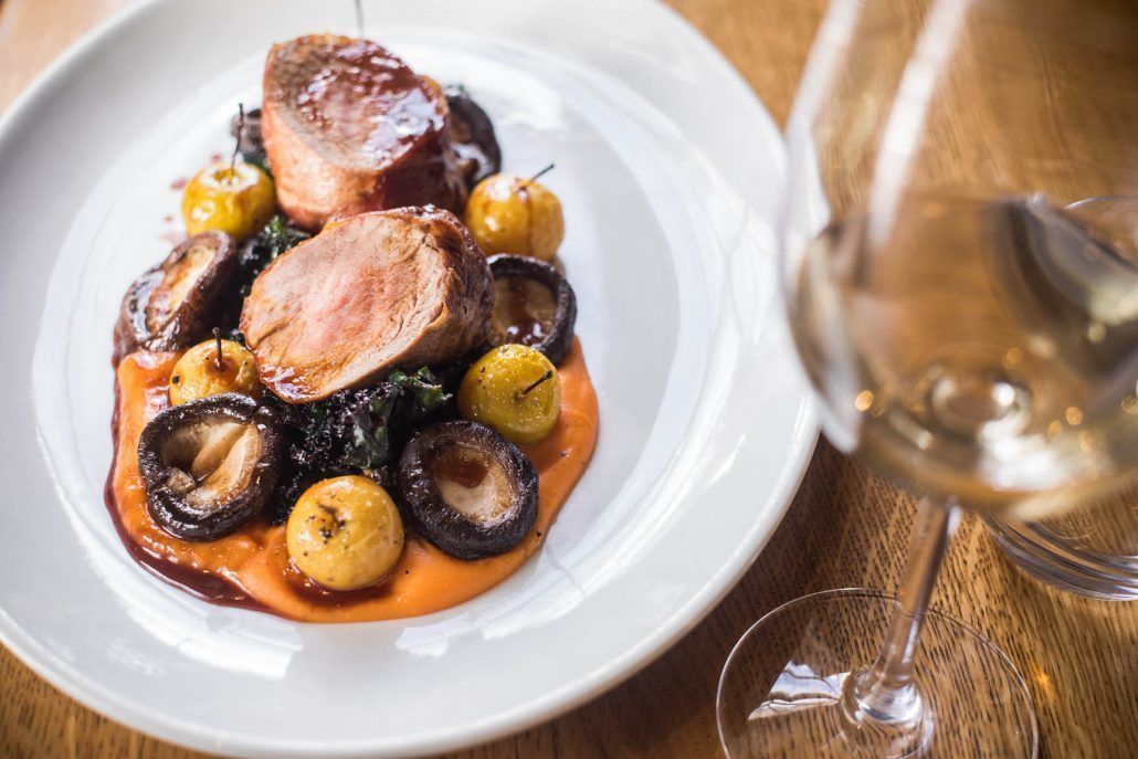 A plate of food with a glass of wine.