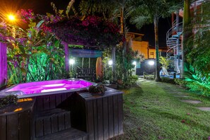 Ein Whirlpool, umgeben von üppiger Vegetation und einer Holzterrasse.