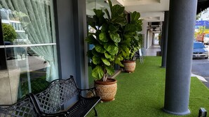 A bench, potted plants, and a column in a building's entrance area. - Royal Queenspark Hotel (Malacca City)