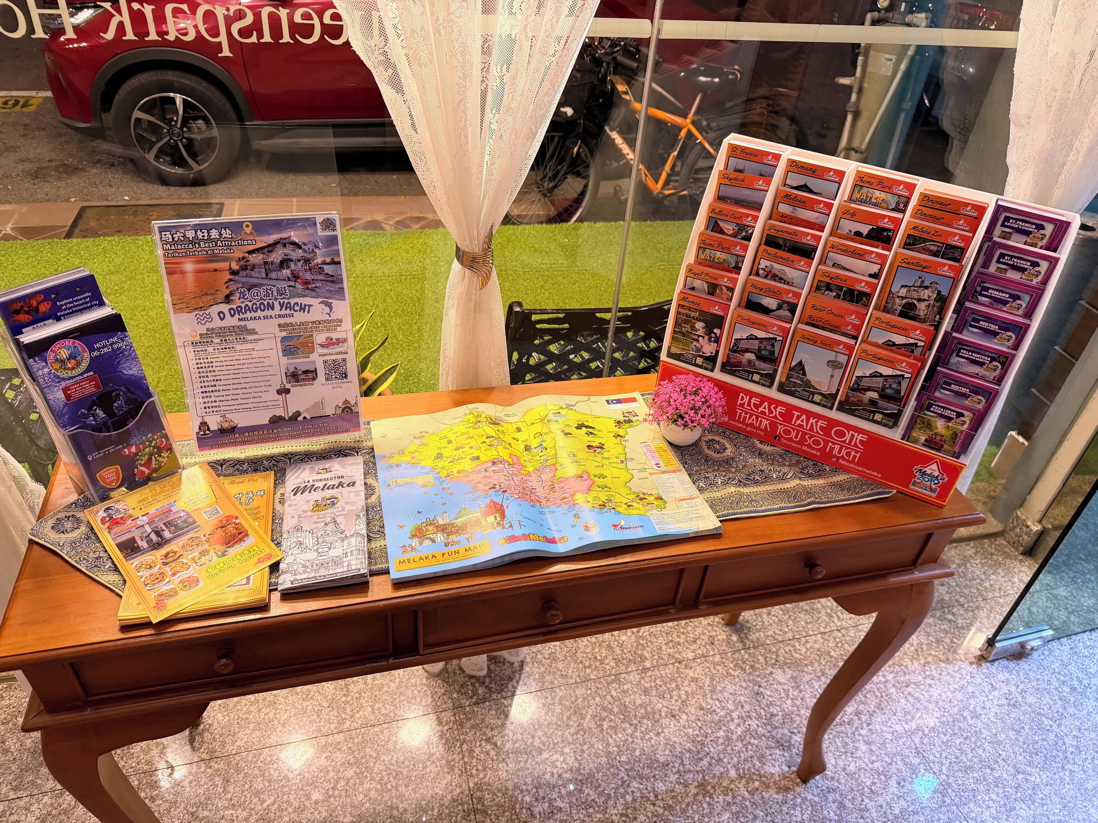 A table with brochures, a map, and a sign that says 'Please take one much.'