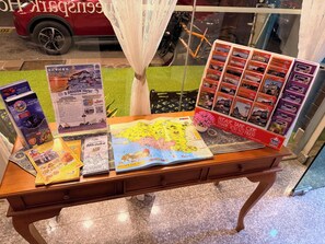 A table with brochures, a map, and a sign that says 'Please take one much.' - Royal Queenspark Hotel (Malacca City)
