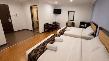 Een hotelkamer met twee bedden, een televisie, een bureau en een stoel.