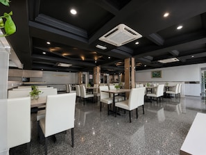 A modern hotel dining area with white furniture, granite flooring, and recessed lighting. - Royal Queenspark Hotel (Malacca City)