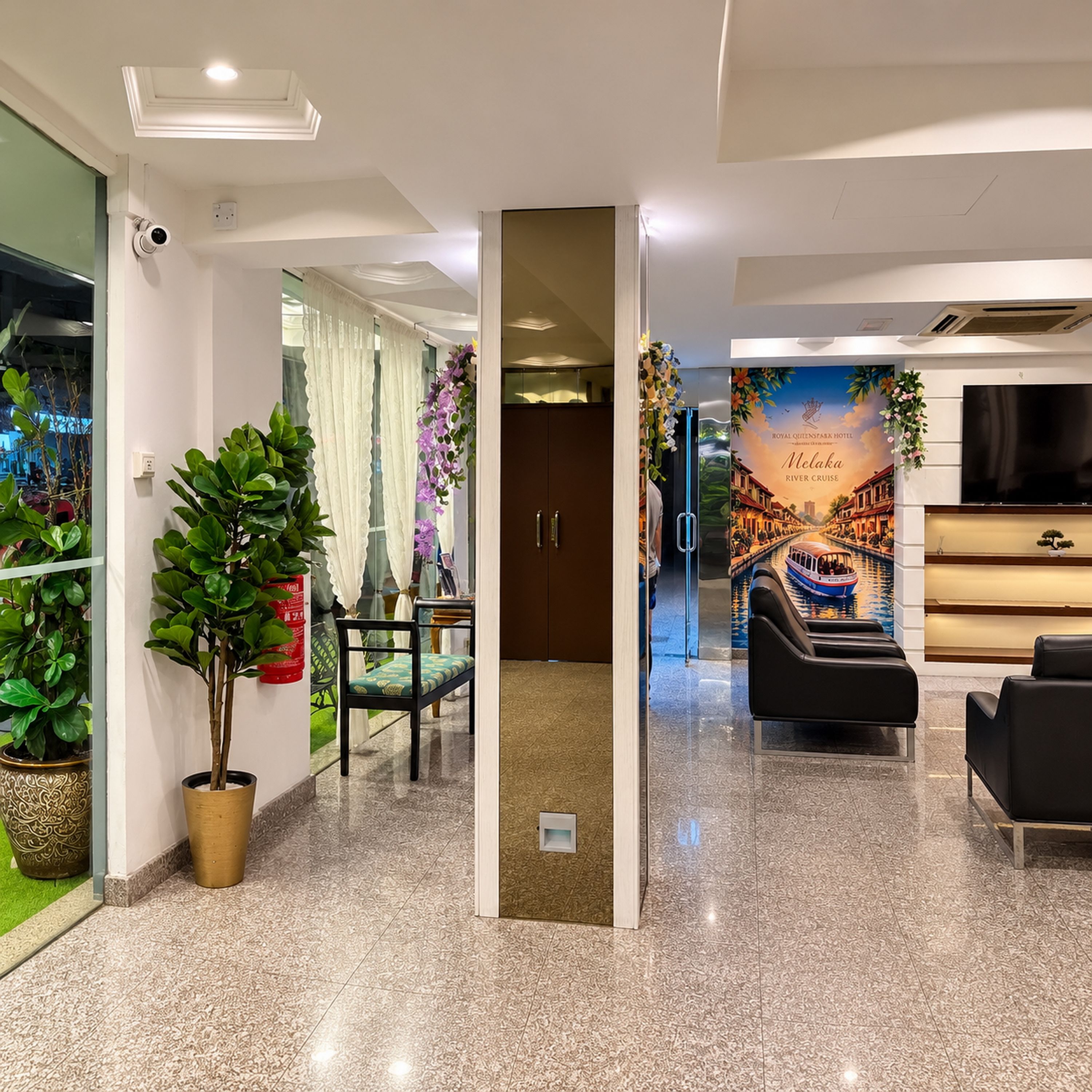 A hotel lobby with a reception desk, seating area, and a large poster of a river cruise.