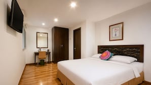 A hotel room with a large bed, a desk with a chair, a television mounted on the wall, and a framed picture above the bed. - Royal Queenspark Hotel (Malacca City)