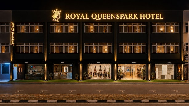 The Royal Queenspark Hotel facade at night with illuminated signage, multiple ground-level entrances, and a well-maintained lawn. - Royal Queenspark Hotel (Malacca City)