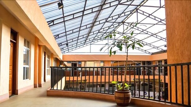 A spacious indoor area with a high ceiling and a glass roof, featuring a central courtyard with a railing and a potted plant. - Sky Hotel Nairobi (Nairobi)
