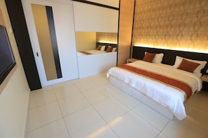 A hotel room with a large bed, a wardrobe, and a mirror.