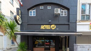 Een hotel met een zwart gevel, een bord waarop 