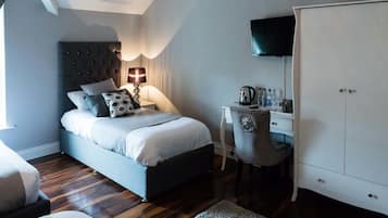Una camera da letto con un letto, un comodino, una lampada, un armadio e una scrivania con una sedia.