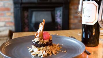 Un postre en un plato con una botella de vino al fondo.