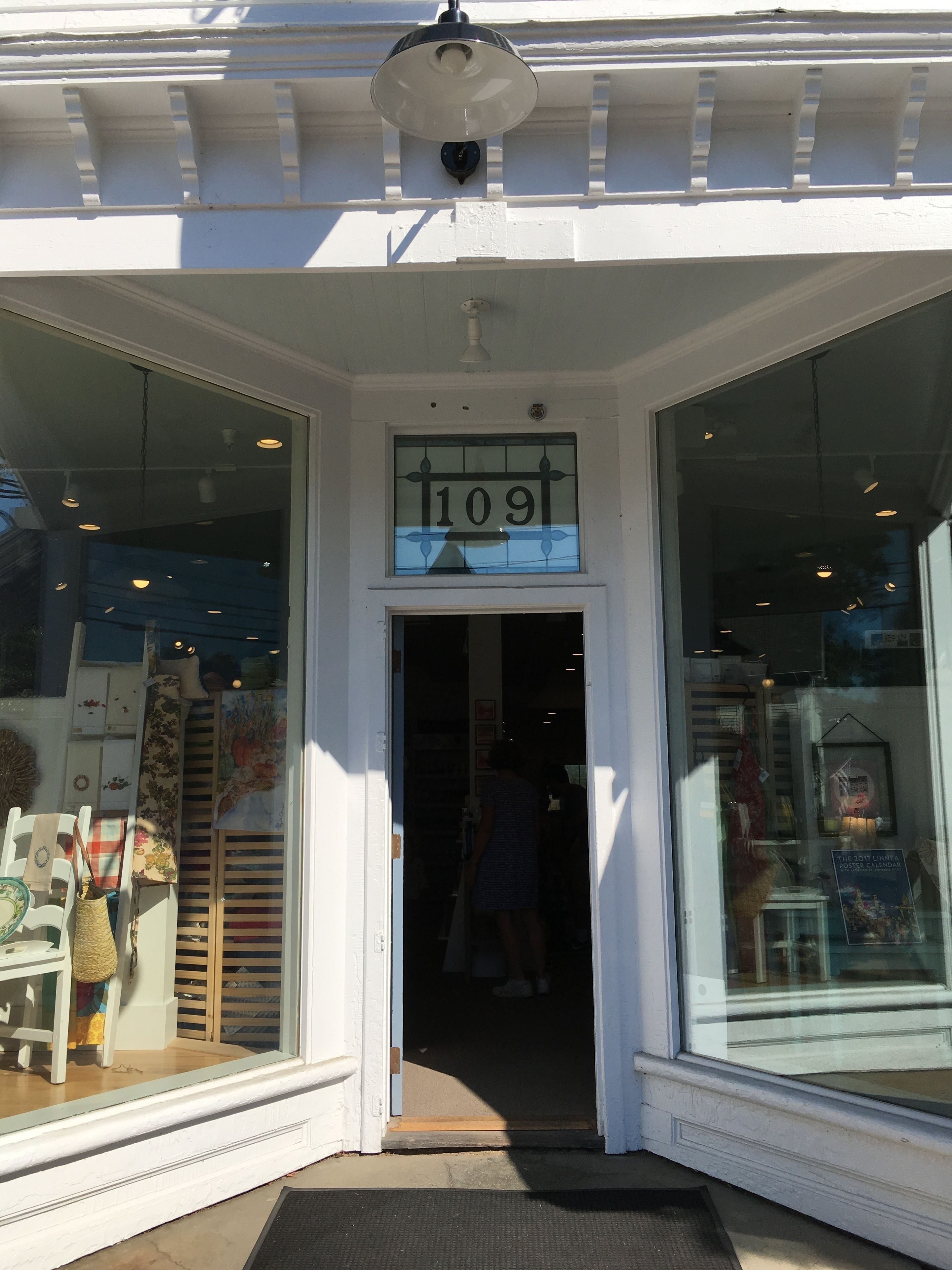 A storefront with a large window display, a door with the number 109, and a bell above the door.