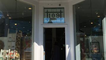 A storefront with a large window display, a door with the number 109, and a bell above the door.