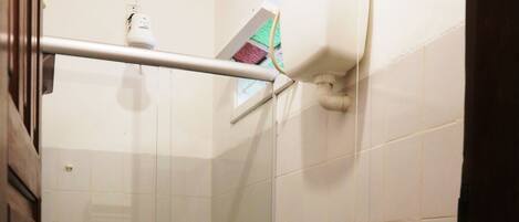 Un baño con inodoro, ducha y puerta de vidrio.