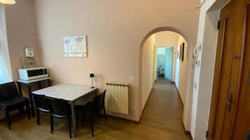 A hallway with a dining area, a radiator, and a wooden door.