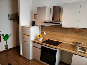 Een moderne keuken met een houten aanrecht, een roestvrijstalen spoelbak en een inbouwoven.