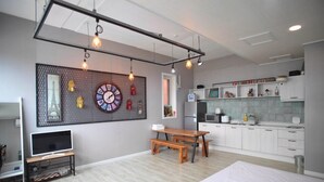 A modern apartment with a kitchen, dining area, and a large wall clock. - Nangman Sea (Yeosu)