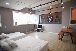 Una habitación moderna con cama, escritorio y ventana grande.