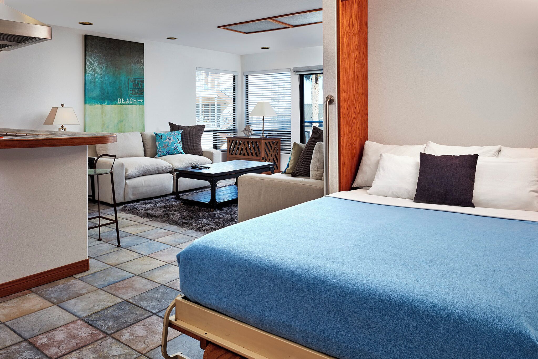 Une chambre d’hôtel avec un lit, deux canapés, une petite table et une vue sur l’extérieur.