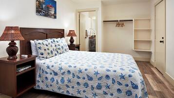 A neatly arranged bedroom with a bed, two bedside lamps, a nightstand, a wardrobe, and a mirror.
