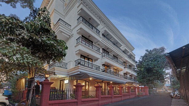Un hotel de varios pisos con un estilo arquitectónico clásico, con balcones y barandillas ornamentadas y una entrada bien iluminada.