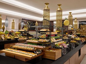 Un bufé con diversos alimentos y jarrones decorativos.