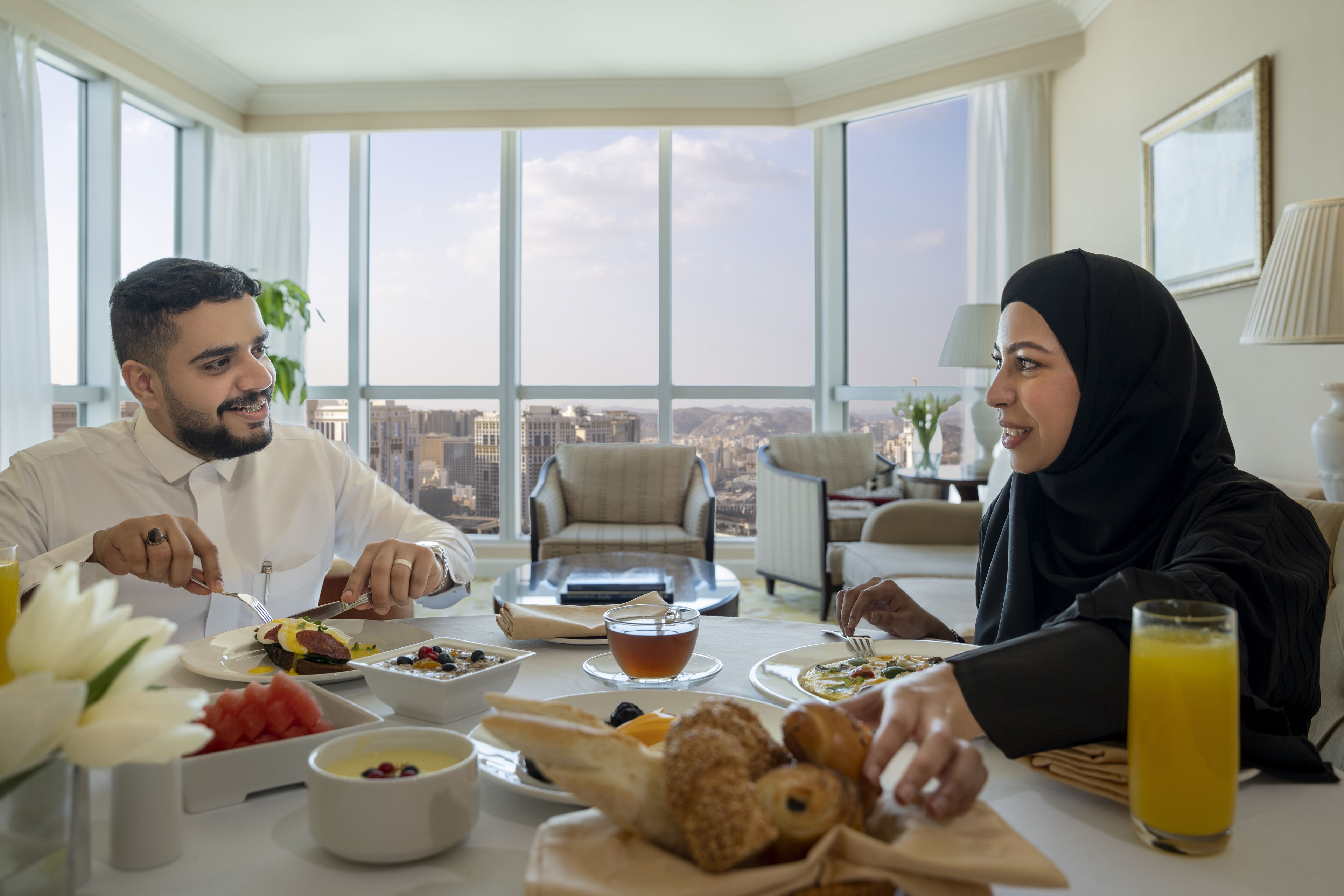 A dining table with breakfast items and a city view.