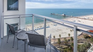 Un balcón con vistas a una playa, un muelle y un cielo despejado.