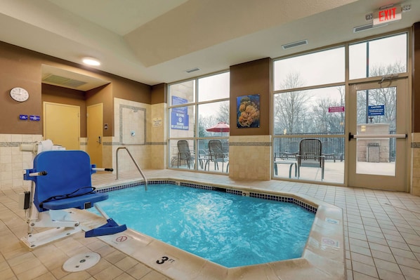 An indoor swimming pool with a blue chair, a clock, and a sign indicating no diving. - Drury Inn & Suites Charlotte Arrowood (Charlotte)