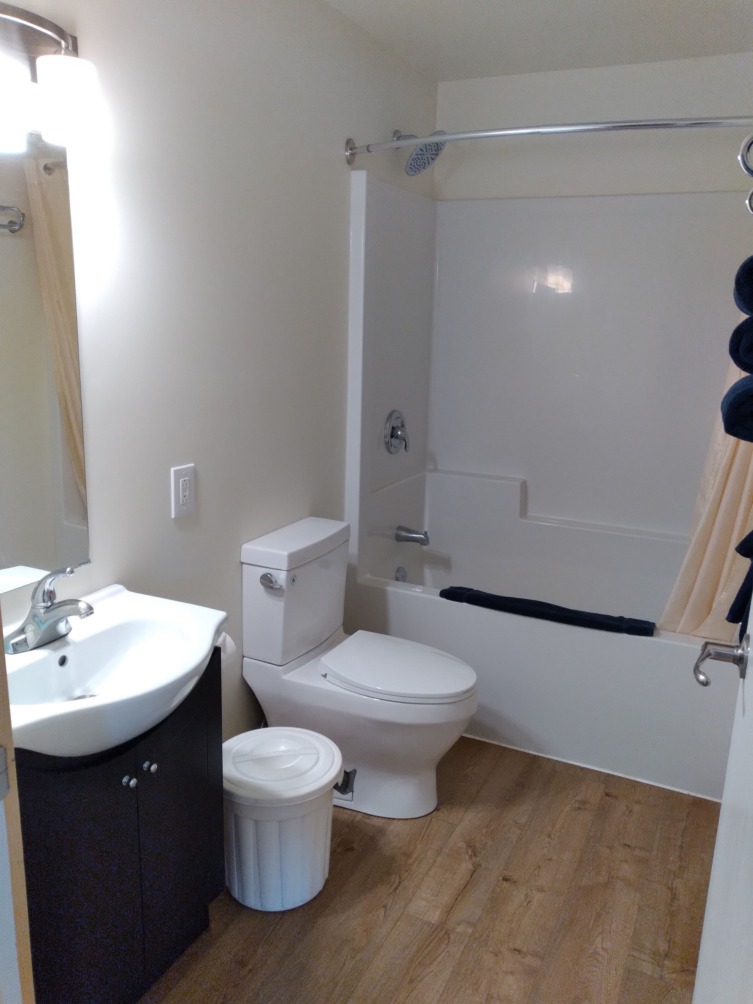 Un baño con lavamanos, inodoro y bañera blancos.