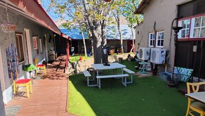 A courtyard with artificial grass, a picnic table, and chairs.