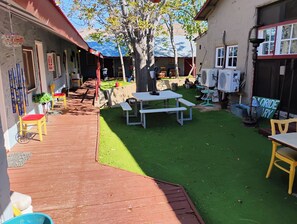 A courtyard with artificial grass, a picnic table, and chairs. - Historic Shep's Miners Inn near Kingman (Chloride)