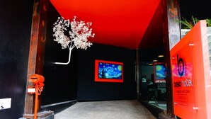 Entrada de hotel con techo rojo, una obra de arte enmarcada y un letrero que dice 'hotel básico'.