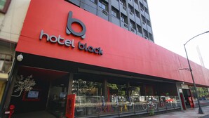 Un hotel con una fachada roja destacada y una entrada de vidrio amplia.