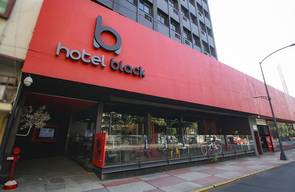 A hotel with a prominent red facade and a large glass entrance. - Hotel Black (Mexico City)