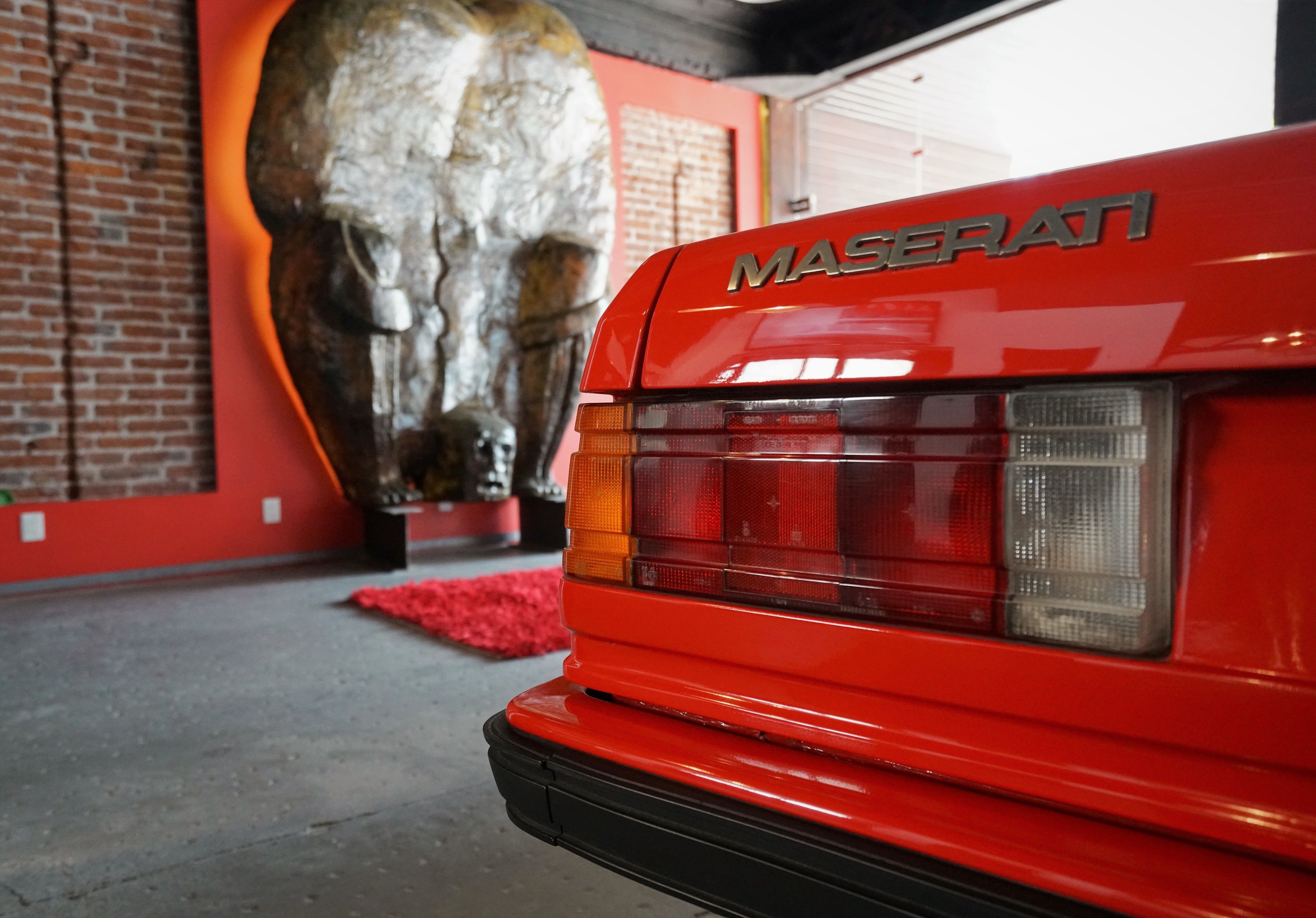 A red Maserati car with the brand name visible on the rear.