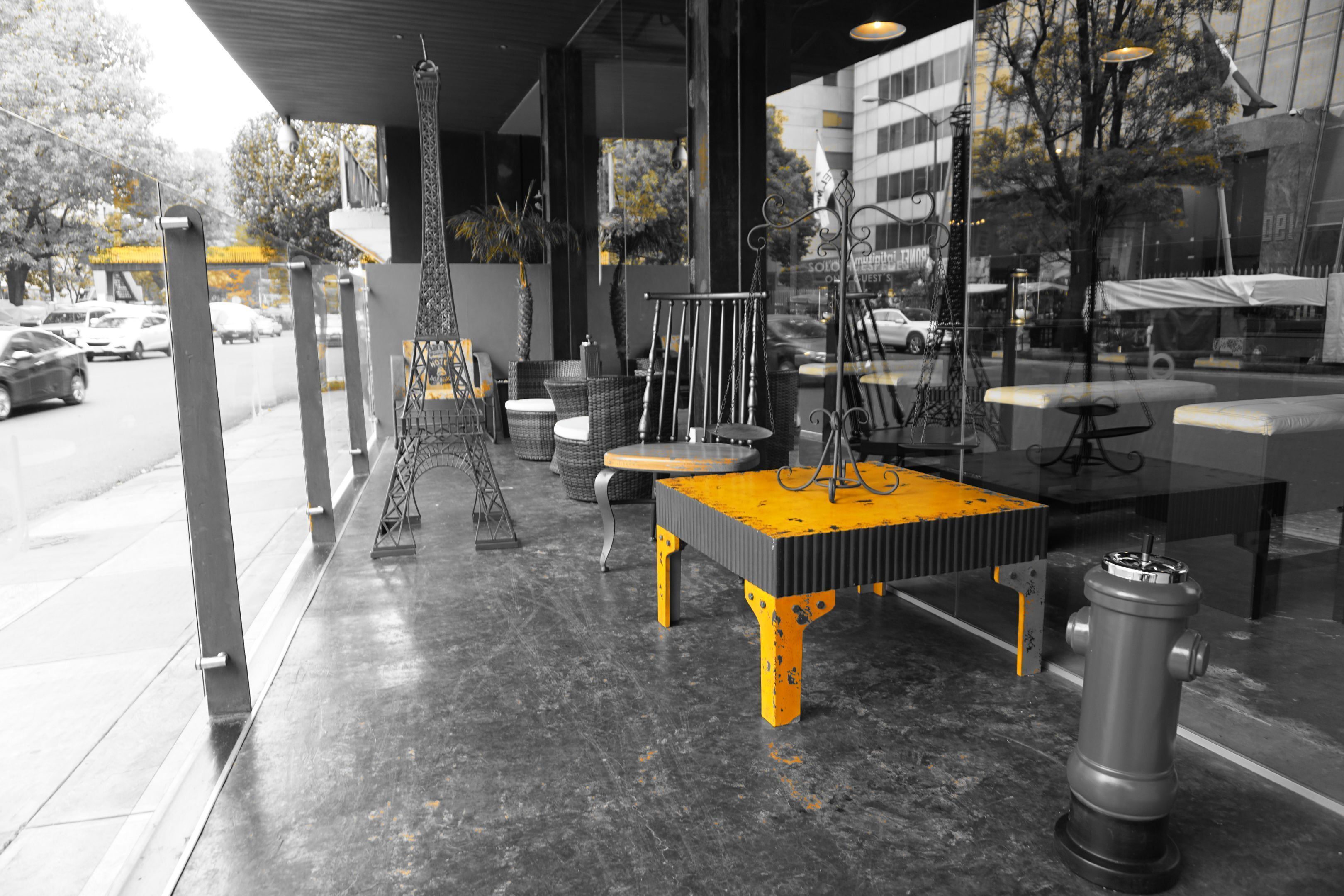 A modern indoor seating area with a central table, chairs, and a decorative metal structure resembling the Eiffel Tower.
