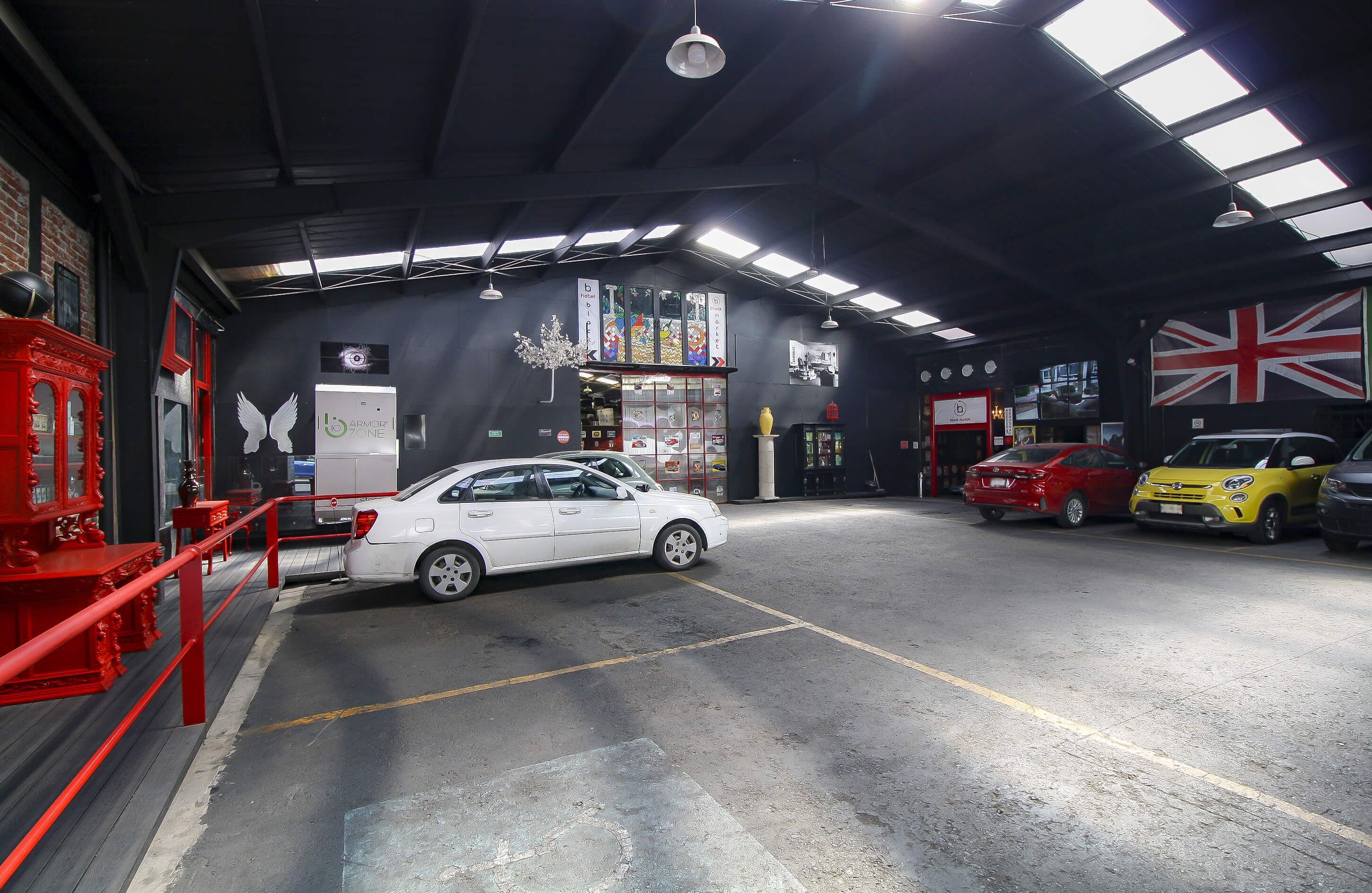 A car wash facility with multiple cars, a red fire extinguisher, and a British flag.
