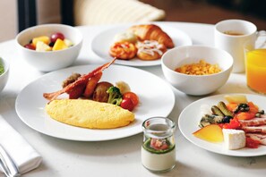 Enjoy a hearty breakfast with a selection of dishes, including omelettes, croissants, fresh fruit, and more.